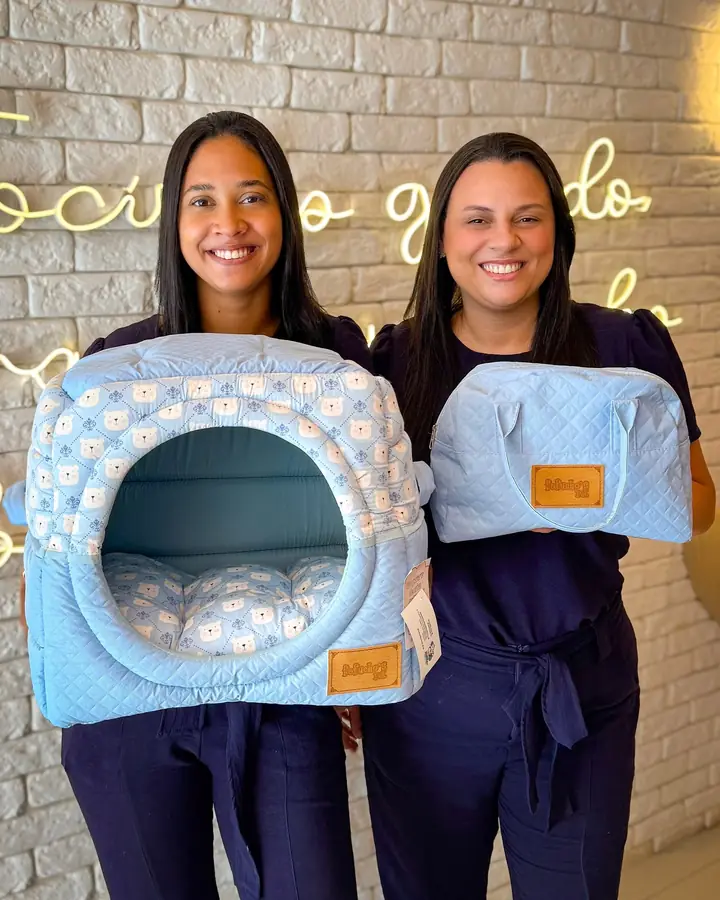 Equipo mostrando camitas y bolsos del pet shop